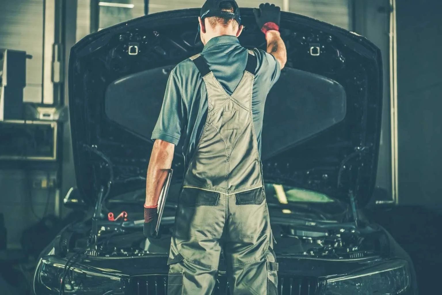 مکانیک در حال سرویس خودرو با کاپوت باز